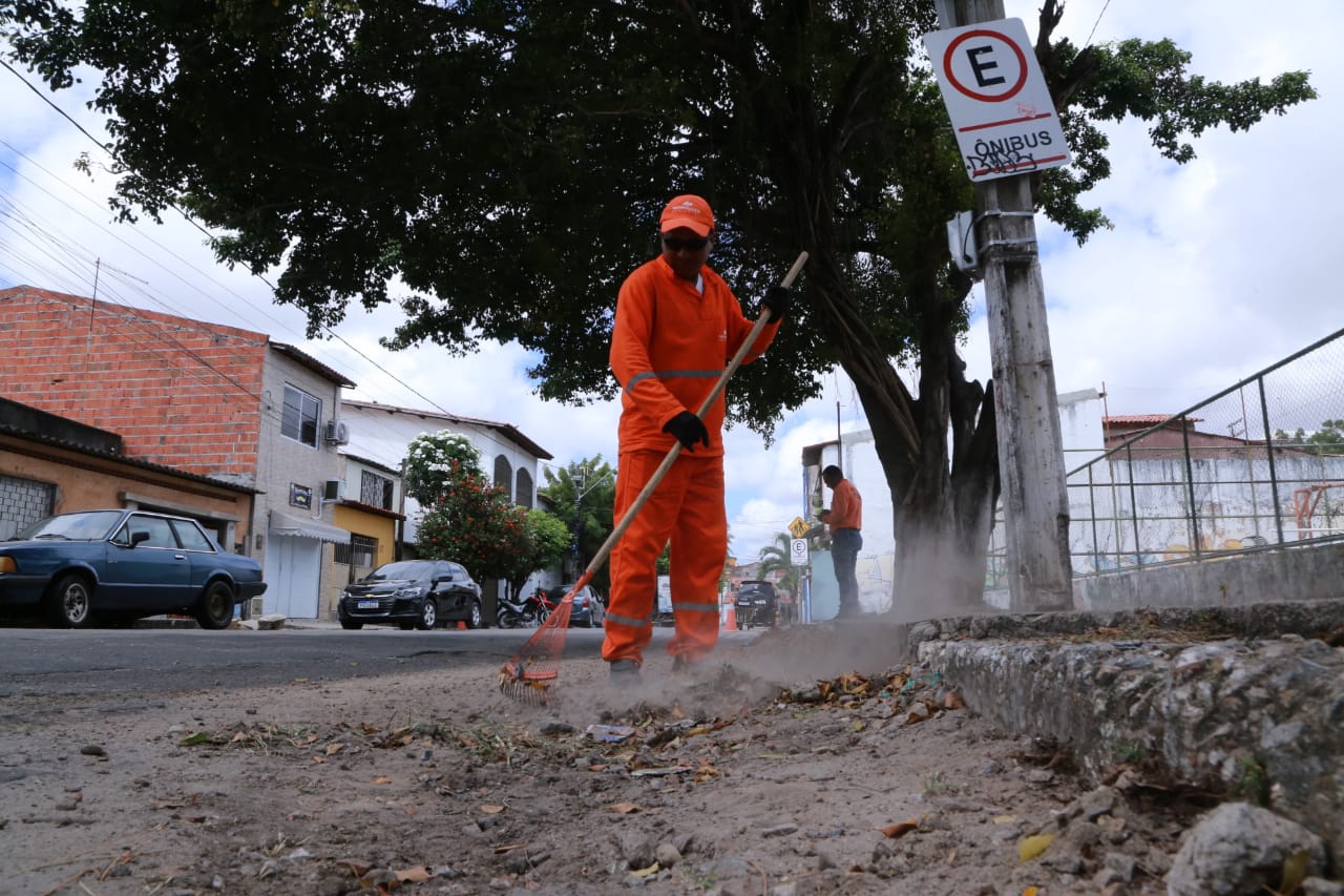 homem varrendo uma via